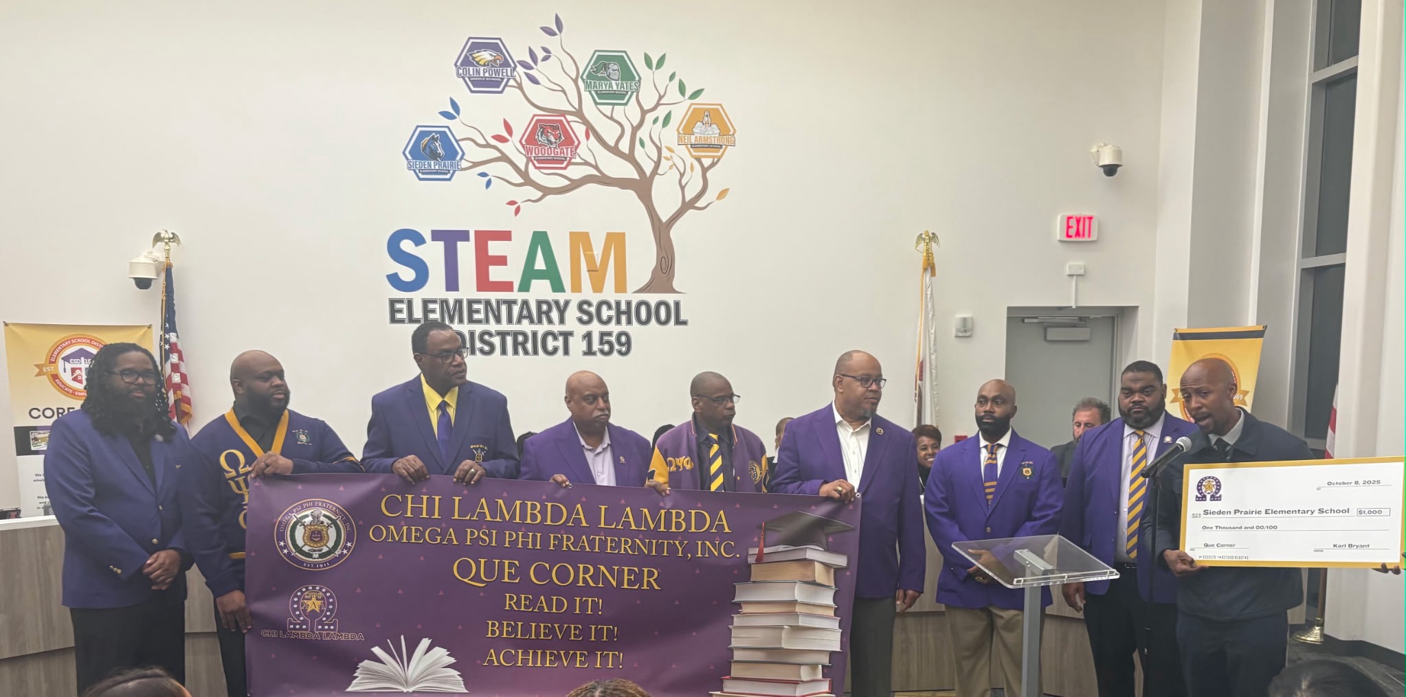 Brothers of Chi Lambda Lambda present a $1,000 check to Sieden-Prairie Elementary School at STEAM Elementary School District 159.